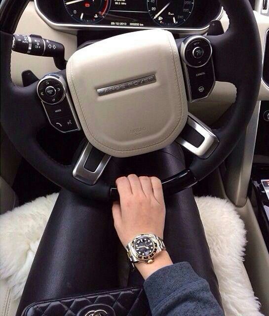 Girl with Rolex and Range Rover steering wheel.