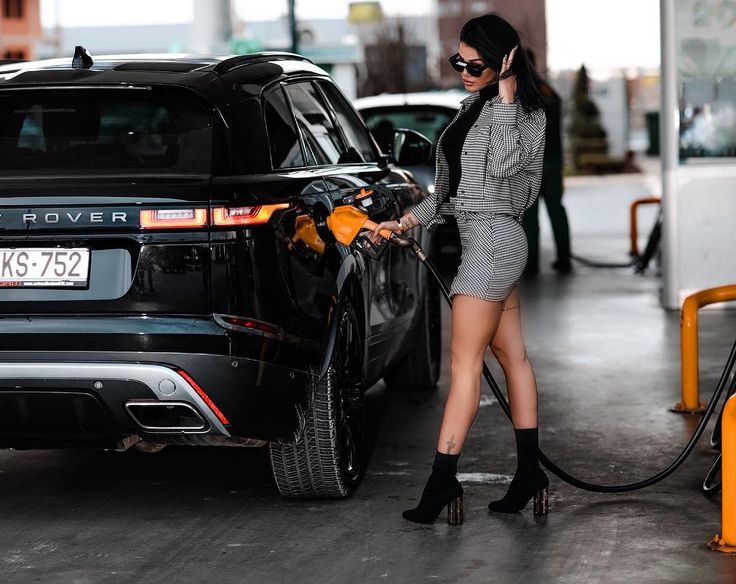 Girl filling a Range Rover with fuel.