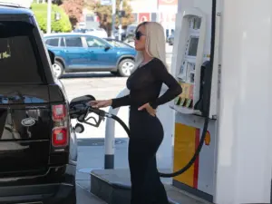 Kim Kardashian filling up her Range Rover at a gas station.