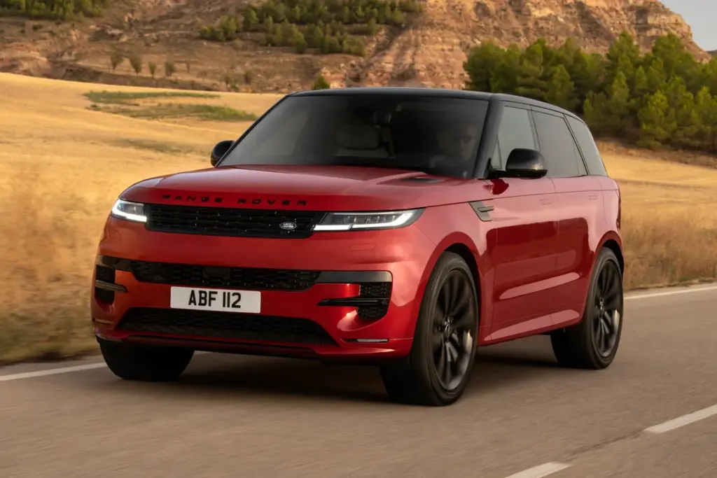 Red Range Rover Sport driving on road.